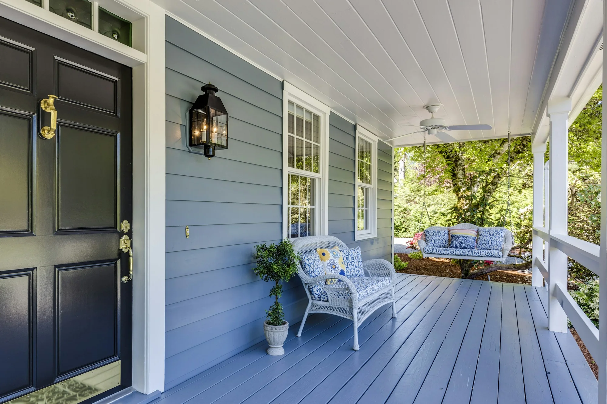 Covered porch with seating and blue siding